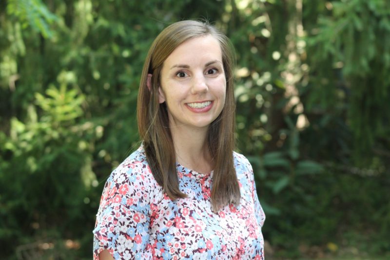 Woman with light brown hair in a floral blouse.