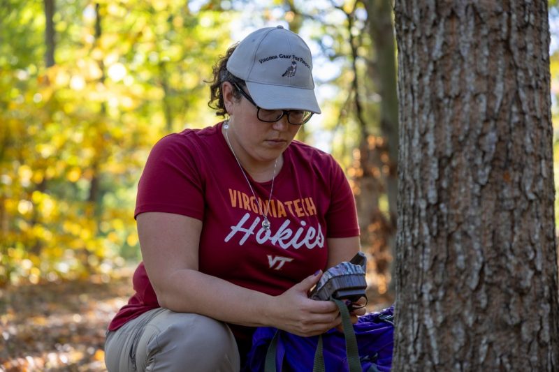 woman with gray hat and a maroon virginia tech shirt in the woods