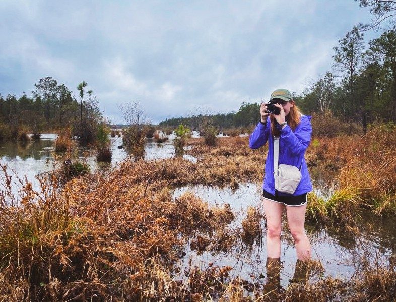 Sydney Haney works in the field to with her camera to gather images.