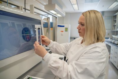 This photo shows Megan Naff in the Genomics Sequencing Center lab.
